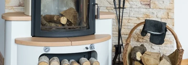 Kamin mit Kaminbesteck und Holzkorb